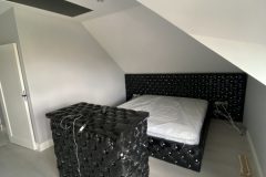 Czarne łóżko chesterfield z materacem i szafka TV z windą – ujęcie z perspektywy